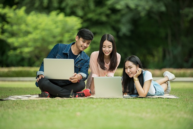 A group of diverse nursing students studying together with laptops and textbooks, symbolizing 